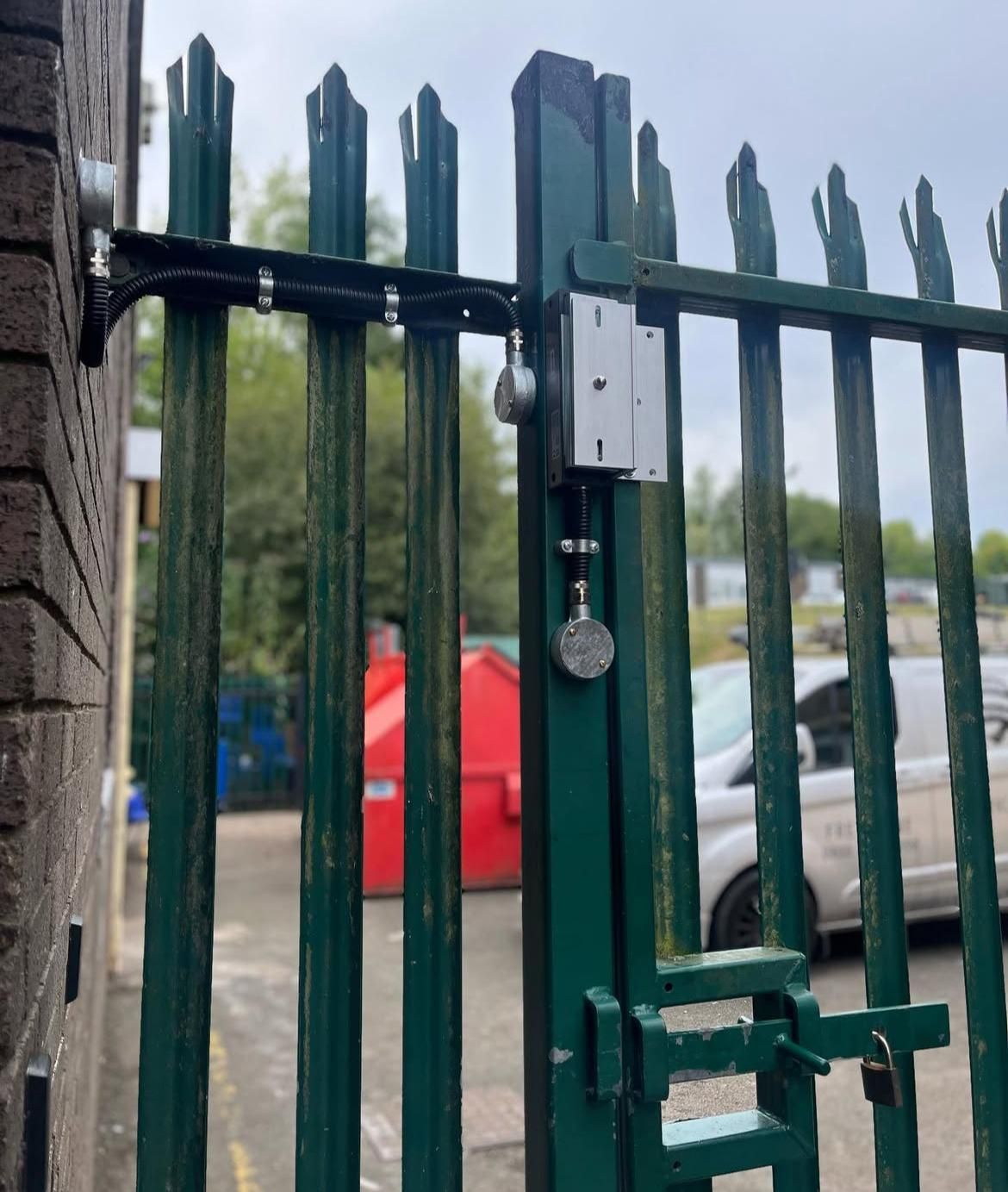 An electromagnetic lock and cabling fitted to a steel palisade gate.